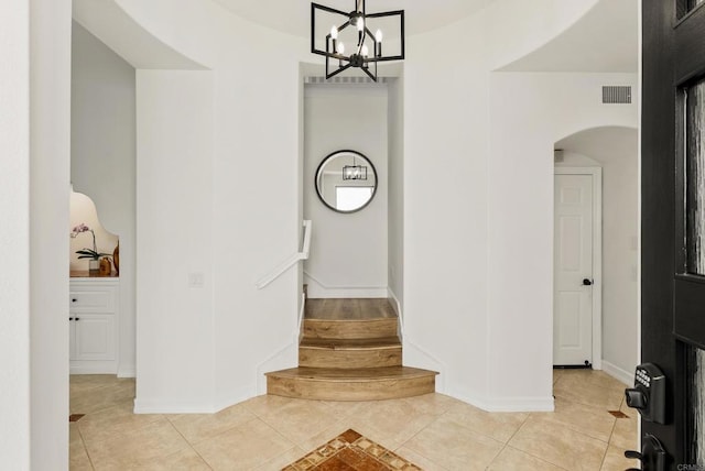 6774 Caurina Ct, Carlsbad, CA 92011 - stairs with tile patterned flooring, arched walkways, and a chandelier