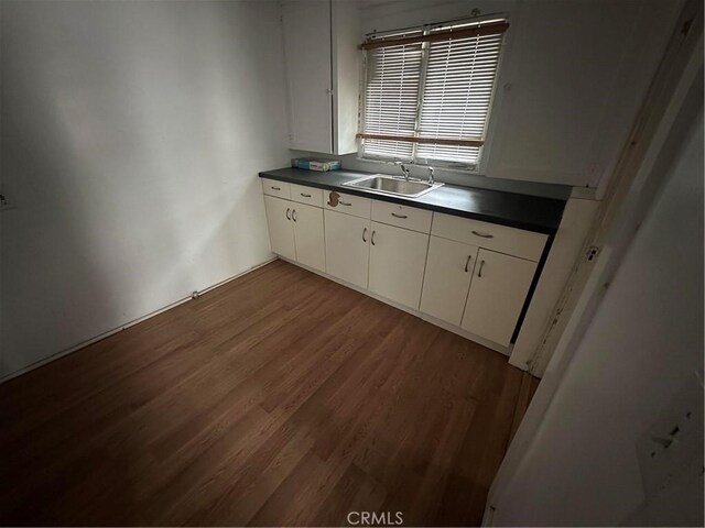 1116 S Barrington Ave, Los Angeles, CA 90049 - kitchen with dark countertops, wood finished floors, white cabinetry, and freestanding refrigerator