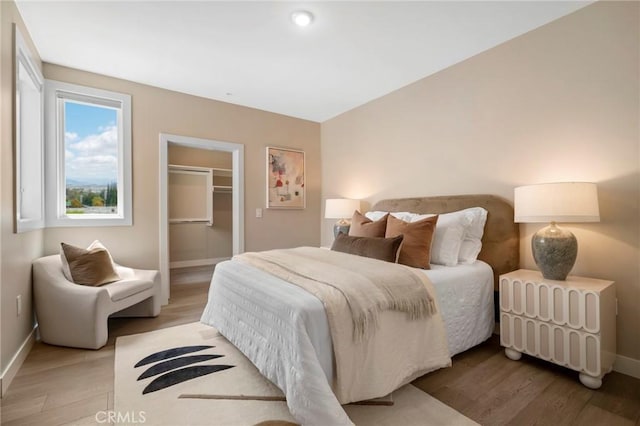39 S Los Robles Ave Unit 5012, Pasadena, CA 91101 - bedroom featuring wood finished floors, a walk in closet, and a closet