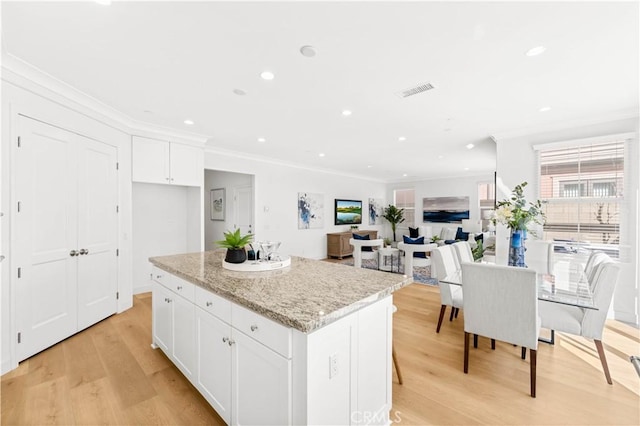 112 Velvet Leaf, Irvine, CA 92620 - kitchen with crown molding, a kitchen island, white cabinets, light wood finished floors, and recessed lighting