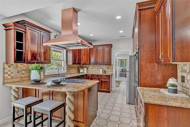 10912 Nighthawk Cir, Fountain Valley, CA 92708 - kitchen featuring island exhaust hood, a peninsula, tasteful backsplash, a breakfast bar area, and recessed lighting