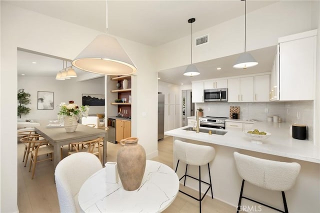 45 Oaktree Ln, Rolling Hills Estates, CA 90274 - kitchen with appliances with stainless steel finishes, backsplash, a peninsula, white cabinetry, and light countertops