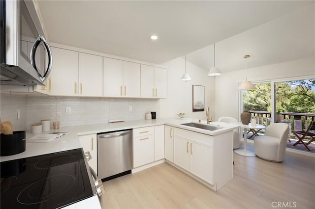 45 Oaktree Ln, Rolling Hills Estates, CA 90274 - kitchen with appliances with stainless steel finishes, light countertops, tasteful backsplash, a peninsula, and light wood-style floors
