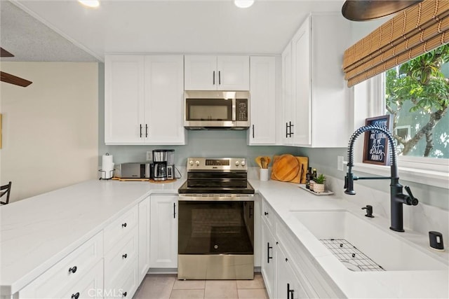 5160 Atherton Unit 73, Long Beach, CA 90815 - kitchen with appliances with stainless steel finishes, white cabinetry, light tile patterned floors, a peninsula, and recessed lighting