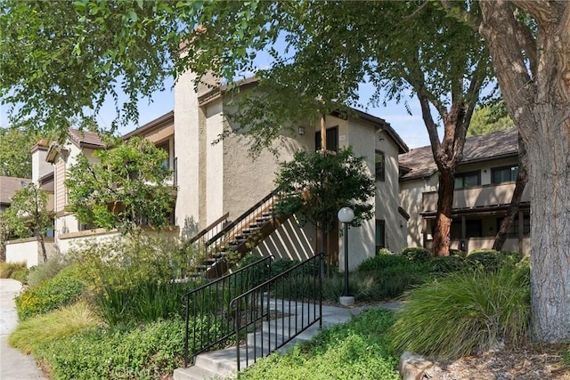 560 N Brea Blvd Unit 24, Brea, CA 92821 - view of side of property featuring stucco siding, stairway, and a chimney
