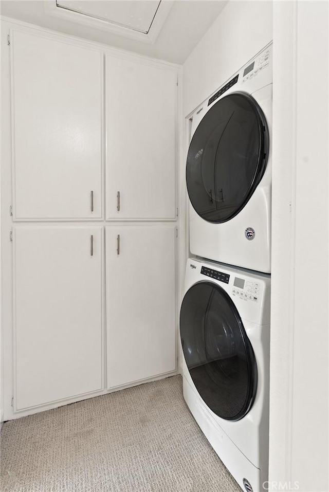 560 N Brea Blvd Unit 24, Brea, CA 92821 - laundry area with stacked washer and clothes dryer, cabinet space, light colored carpet, and attic access