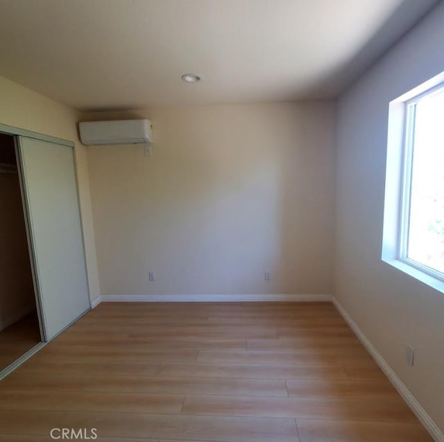 4739 Ivy St, Pico Rivera, CA 90660 - unfurnished bedroom featuring a wall unit AC, light wood-type flooring, a closet, and recessed lighting