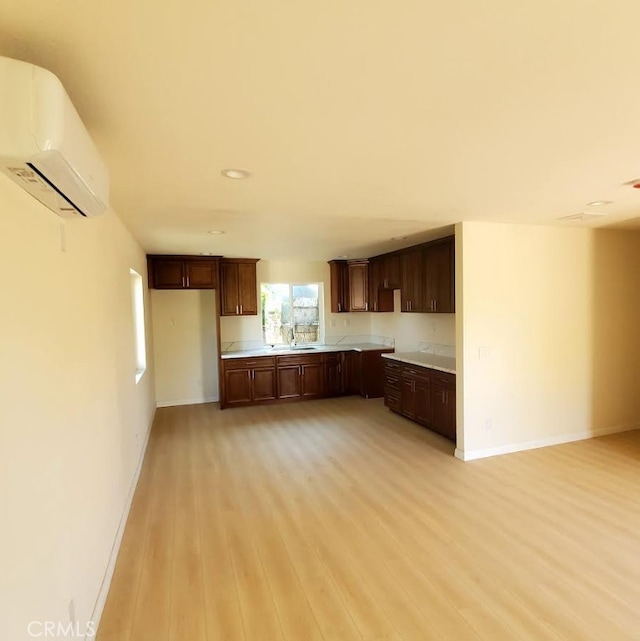 4739 Ivy St, Pico Rivera, CA 90660 - kitchen featuring a wall mounted air conditioner, light wood-style flooring, light countertops, dark brown cabinetry, and recessed lighting