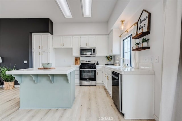 13432 Jubilee Pl, Victorville, CA 92395 - kitchen featuring appliances with stainless steel finishes, tile countertops, light wood-type flooring, and white cabinetry