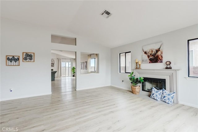 13432 Jubilee Pl, Victorville, CA 92395 - unfurnished living room featuring vaulted ceiling, wood finished floors, and a glass covered fireplace