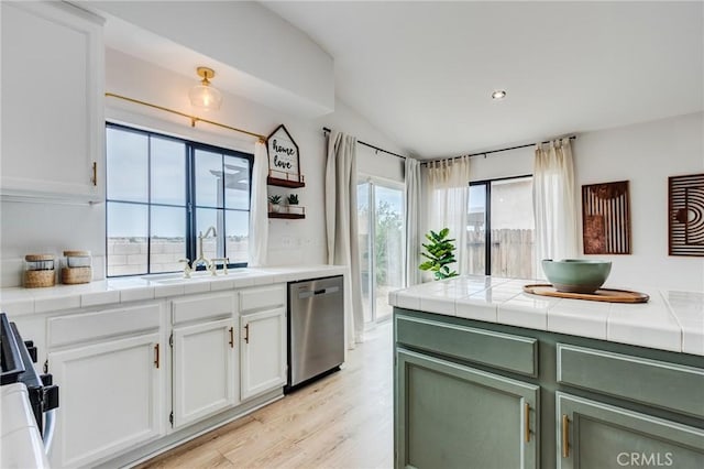 13432 Jubilee Pl, Victorville, CA 92395 - kitchen featuring dishwasher, lofted ceiling, tile countertops, stove, and white cabinetry