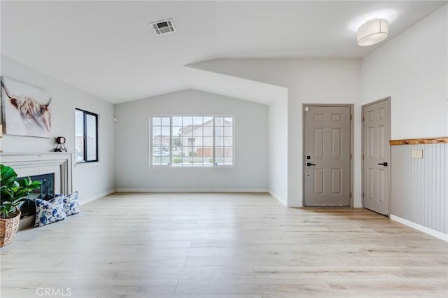 13432 Jubilee Pl, Victorville, CA 92395 - unfurnished living room with lofted ceiling, light wood-style flooring, and a glass covered fireplace