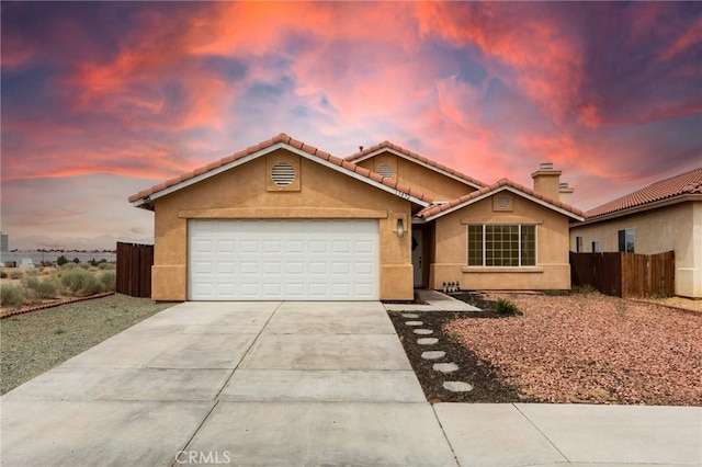 13432 Jubilee Pl, Victorville, CA 92395 - view of front of home featuring stucco siding, concrete driveway, an attached garage, a tile roof, and a chimney