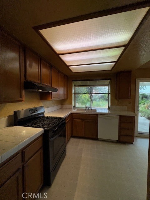 4773 Mount Rainier St, Jurupa Valley, CA 92509 - kitchen featuring white dishwasher, gas stove, under cabinet range hood, tile countertops, and light floors