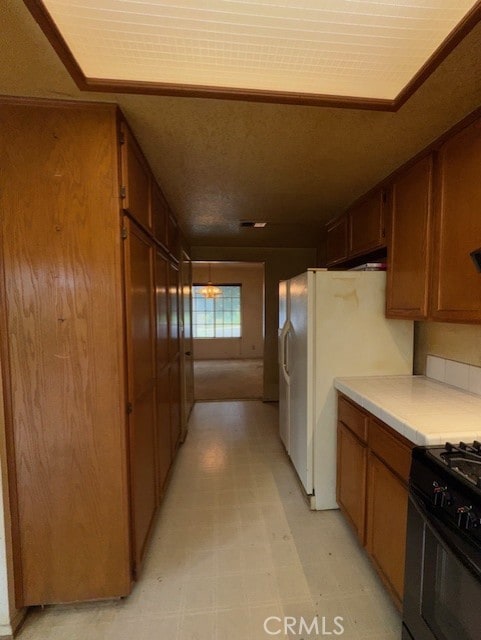 4773 Mount Rainier St, Jurupa Valley, CA 92509 - kitchen featuring light countertops, white refrigerator with ice dispenser, light floors, gas stove, and brown cabinetry