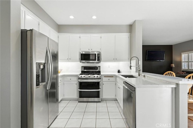 31397 Heitz Ln, Temecula, CA 92591 - kitchen featuring appliances with stainless steel finishes, a peninsula, tasteful backsplash, white cabinets, and recessed lighting