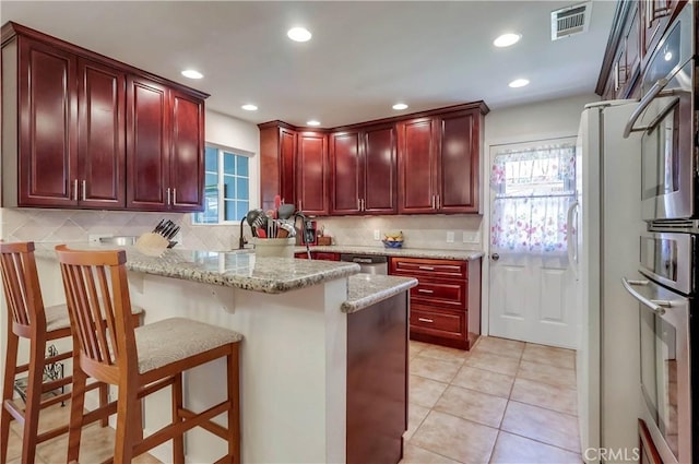 1332 Carew St, San Dimas, CA 91773 - kitchen featuring dark brown cabinets, healthy amount of natural light, a peninsula, backsplash, and recessed lighting