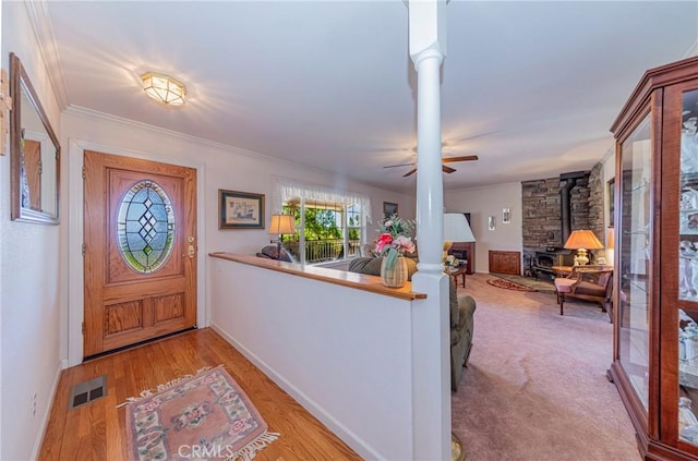 53235 Finegold Creek Ct, North Fork, CA 93643 - foyer entrance featuring a wood stove, ceiling fan, wood finished floors, and crown molding
