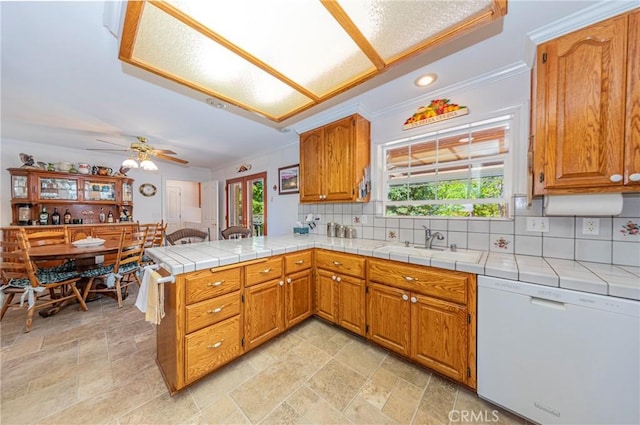53235 Finegold Creek Ct, North Fork, CA 93643 - kitchen featuring dishwasher, ornamental molding, tasteful backsplash, a peninsula, and brown cabinets