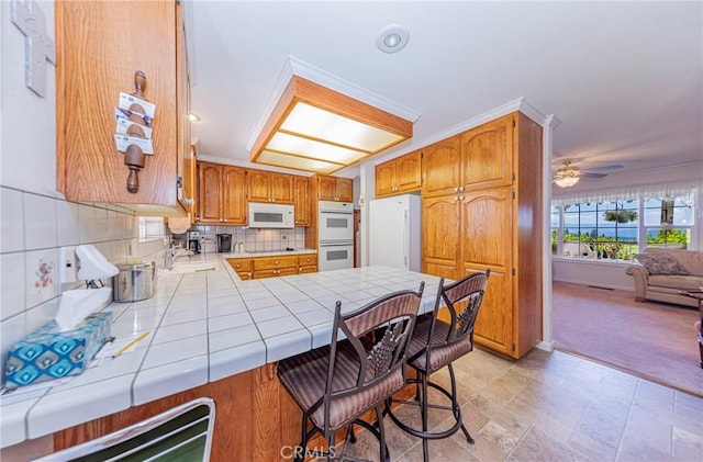 53235 Finegold Creek Ct, North Fork, CA 93643 - kitchen with white appliances, tile countertops, a peninsula, decorative backsplash, and open floor plan