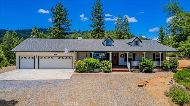 53235 Finegold Creek Ct, North Fork, CA 93643 - cape cod home with driveway, an attached garage, covered porch, a chimney, and a shingled roof
