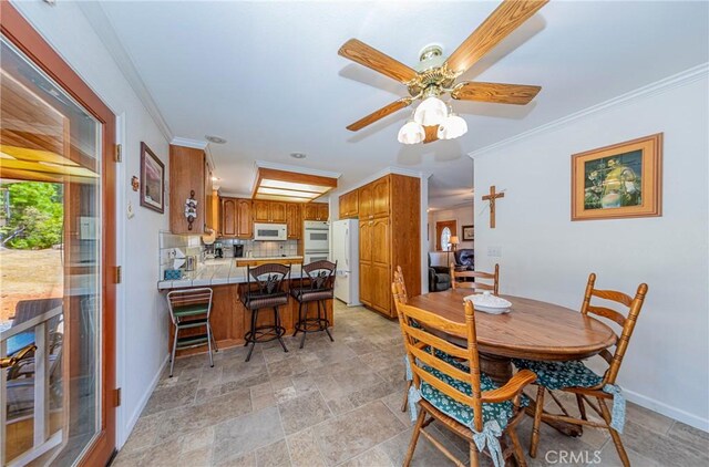 53235 Finegold Creek Ct, North Fork, CA 93643 - dining space featuring crown molding, a ceiling fan, and light stone finish flooring