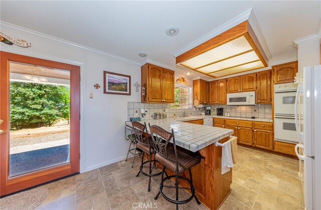 53235 Finegold Creek Ct, North Fork, CA 93643 - kitchen featuring white appliances, a peninsula, tile counters, backsplash, and light stone finish flooring