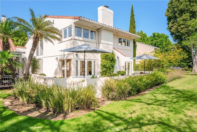417 Vista Suerte, Newport Beach, CA 92660 - back of property featuring a chimney, a lawn, french doors, a tiled roof, and stucco siding