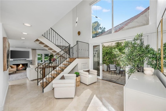 417 Vista Suerte, Newport Beach, CA 92660 - living area with stairway, a warm lit fireplace, a high ceiling, and recessed lighting