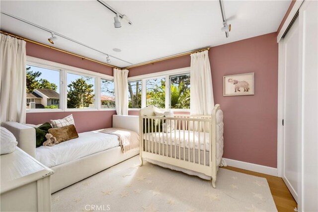 417 Vista Suerte, Newport Beach, CA 92660 - bedroom featuring rail lighting, wood finished floors, and a closet