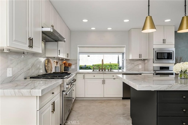 417 Vista Suerte, Newport Beach, CA 92660 - kitchen featuring stainless steel appliances, wall chimney range hood, white cabinets, backsplash, and decorative light fixtures