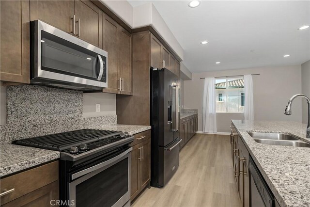 11118 Bunker Ln, Whittier, CA 90604 - kitchen featuring stainless steel appliances, light wood finished floors, light stone counters, dark brown cabinetry, and recessed lighting