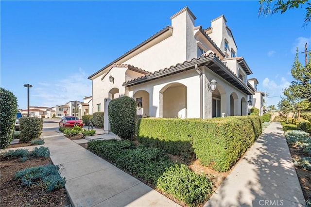 11118 Bunker Ln, Whittier, CA 90604 - view of home's exterior featuring stucco siding, a tile roof, and a chimney