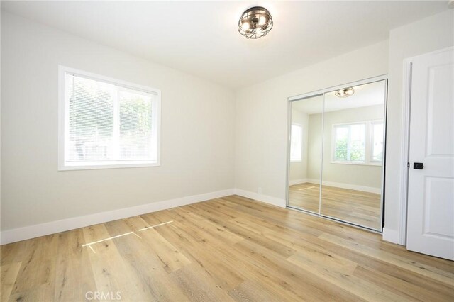 903 E 7th St, Pomona, CA 91766 - unfurnished bedroom featuring light wood-type flooring and a closet