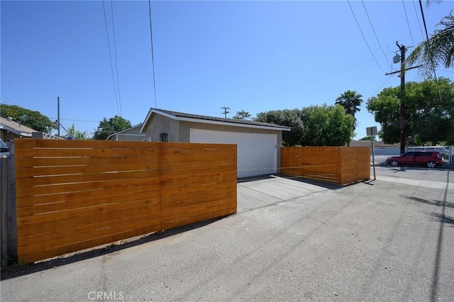 903 E 7th St, Pomona, CA 91766 - view of side of home with a garage and stucco siding