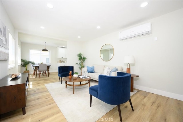 903 E 7th St, Pomona, CA 91766 - living room featuring an AC wall unit, light wood finished floors, and recessed lighting