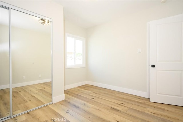 903 E 7th St, Pomona, CA 91766 - unfurnished bedroom with light wood-style floors and a closet