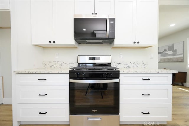 903 E 7th St, Pomona, CA 91766 - kitchen featuring stainless steel appliances, light wood-style flooring, and light stone counters