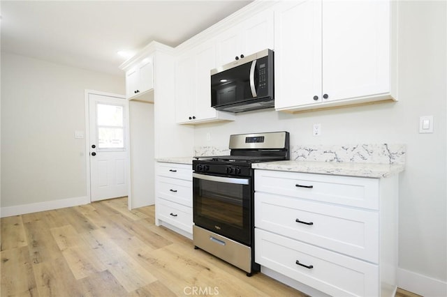 903 E 7th St, Pomona, CA 91766 - kitchen with gas stove, light wood-style flooring, white cabinetry, and light stone countertops