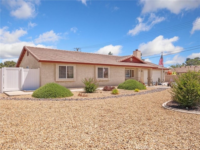 21756 Tussing Ranch Rd, Apple Valley, CA 92308 - rear view of house featuring an attached garage, stucco siding, a tile roof, and a chimney