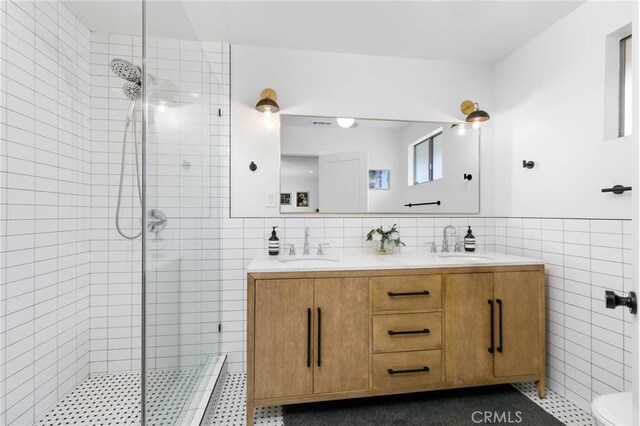 6242 E Pageantry St, Long Beach, CA 90808 - full bathroom featuring tile walls, a tile shower, double vanity, and a wainscoted wall