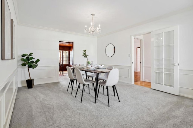 5038 Hastings Rd, San Diego, CA 92116 - carpeted dining space featuring a chandelier, a decorative wall, a wainscoted wall, and ornamental molding