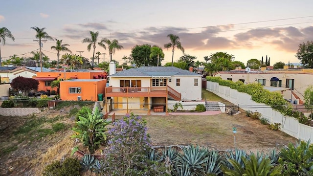 5038 Hastings Rd, San Diego, CA 92116 - back of property at dusk with a fenced backyard, stucco siding, a deck, and stairs