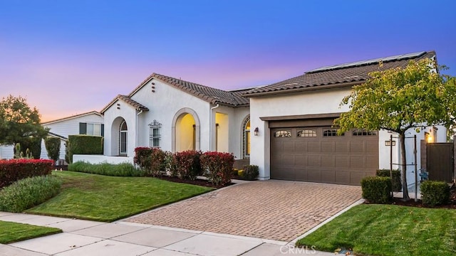 1849 Eucalyptus Rd, Nipomo, CA 93444 - mediterranean / spanish home with decorative driveway, an attached garage, stucco siding, a front lawn, and solar panels