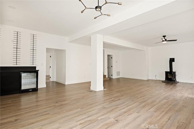 30260 Gremlin Ct, Running Springs, CA 92382 - unfurnished living room featuring a wood stove, light wood finished floors, and a chandelier