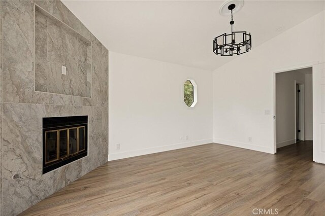 30260 Gremlin Ct, Running Springs, CA 92382 - unfurnished living room with wood finished floors, a chandelier, a tile fireplace, and vaulted ceiling