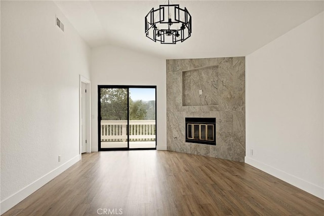 30260 Gremlin Ct, Running Springs, CA 92382 - unfurnished living room with wood finished floors, a chandelier, vaulted ceiling, and a tile fireplace