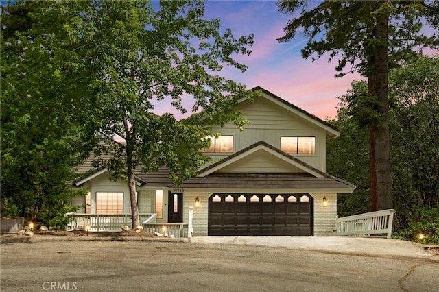 30260 Gremlin Ct, Running Springs, CA 92382 - view of front of property with a porch, a garage, brick siding, and asphalt driveway