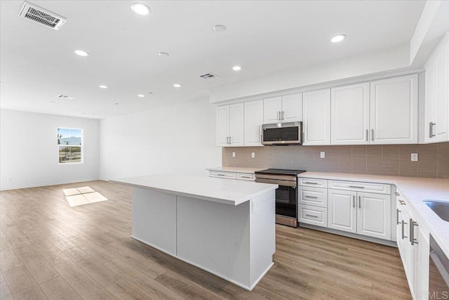 8608 Amherst St, Santee, CA 92071 - kitchen featuring stainless steel appliances, white cabinetry, light countertops, backsplash, and recessed lighting