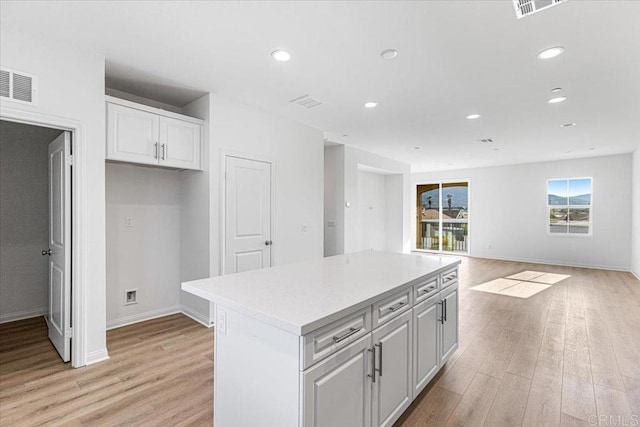 8608 Amherst St, Santee, CA 92071 - kitchen featuring light wood-style floors, white cabinetry, recessed lighting, a kitchen island, and light countertops